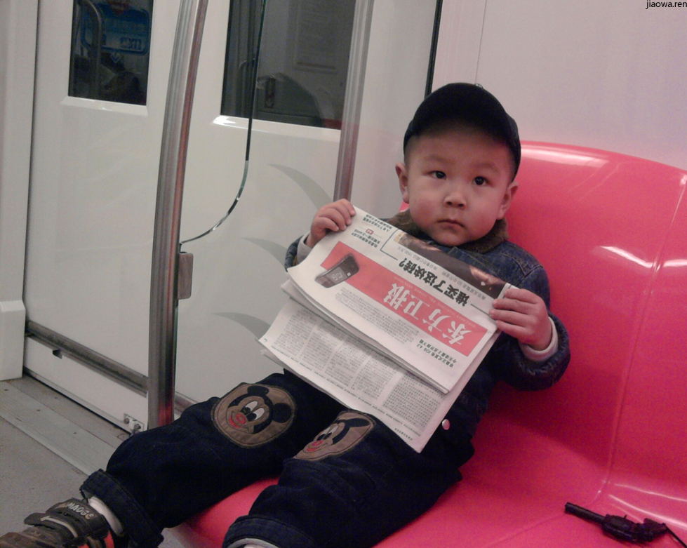 地铁上看报纸的小帅哥