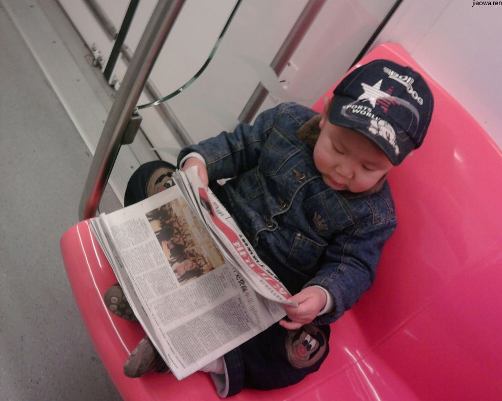 地铁上看报纸的小帅哥